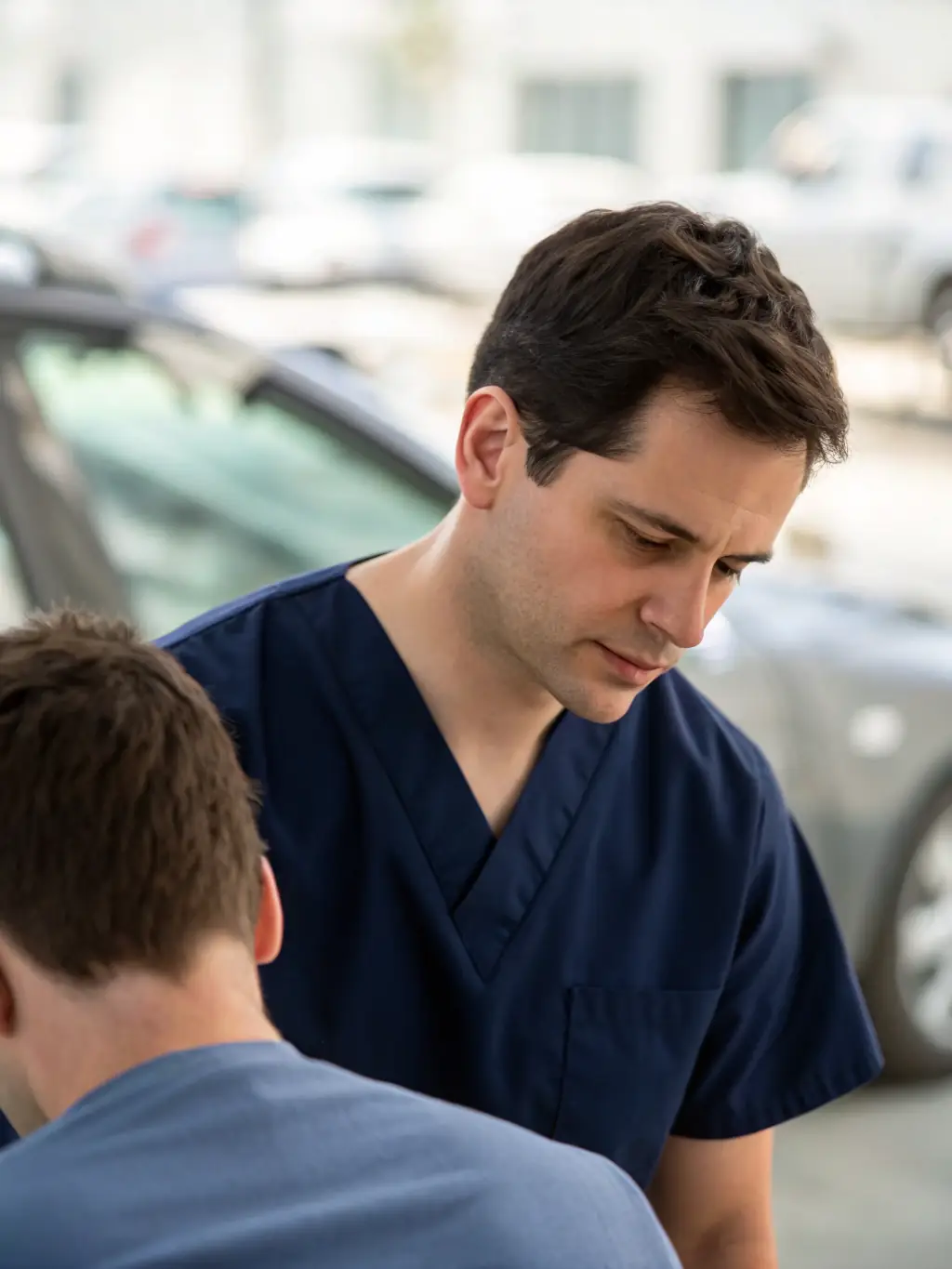 A chiropractor examining a patient with a focus on neck and back alignment, with a blurred car accident scene in the background, symbolizing chiropractic care for auto accident injuries.